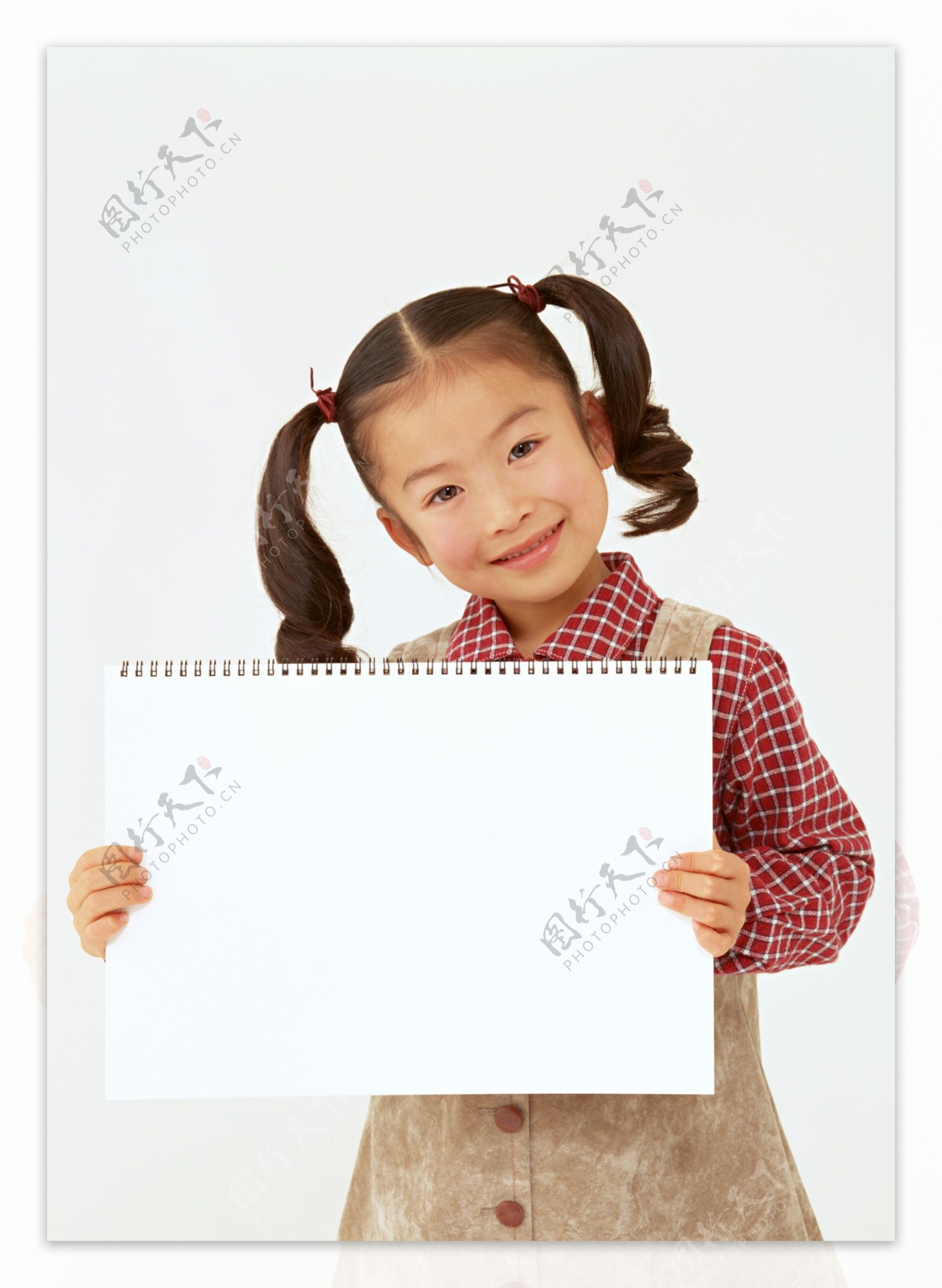 拿着空白卡片的微笑小女孩图片
