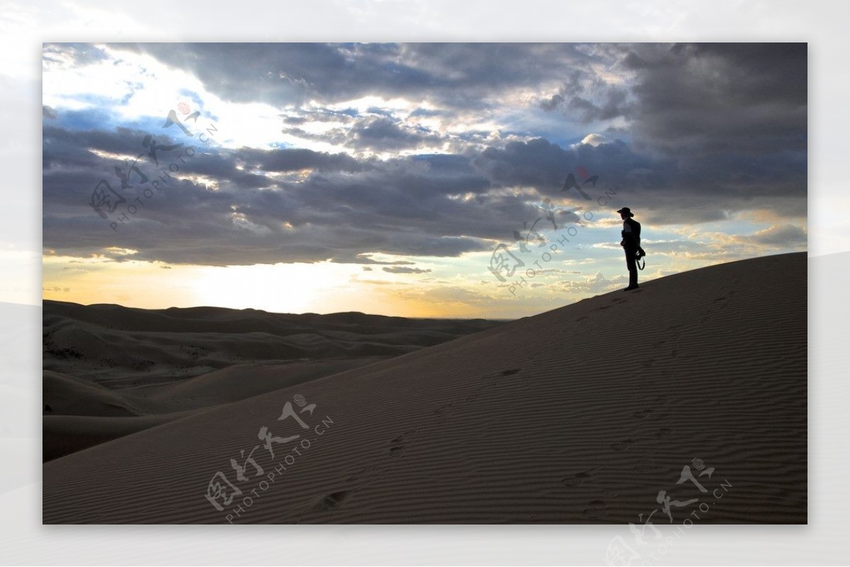 黄昏时在沙漠里的孤独的人图片