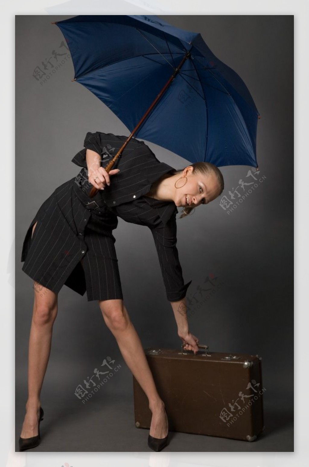 打着雨伞提公务皮箱的商务美女商务特写图片