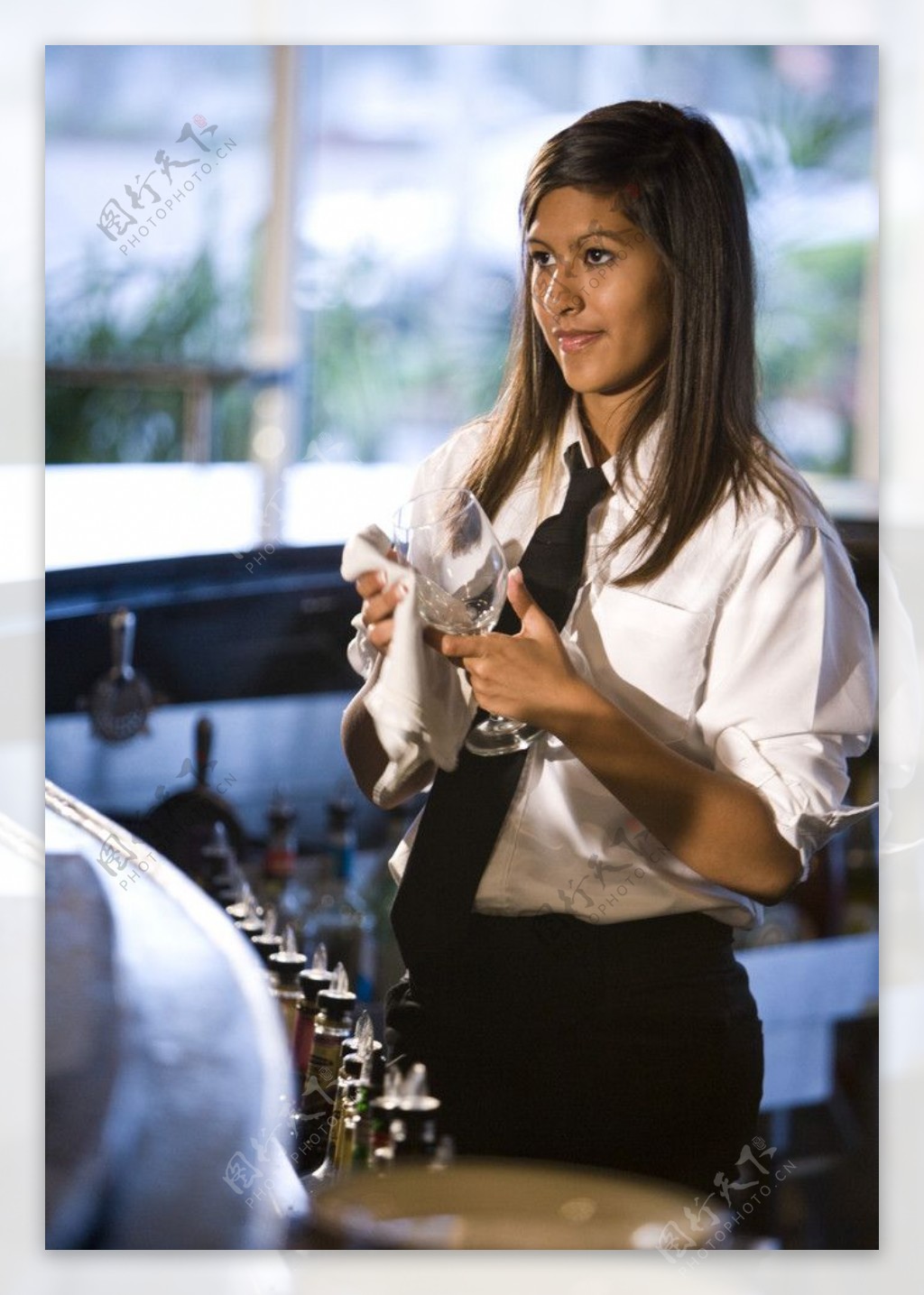正在擦拭玻璃杯的女服务员图片