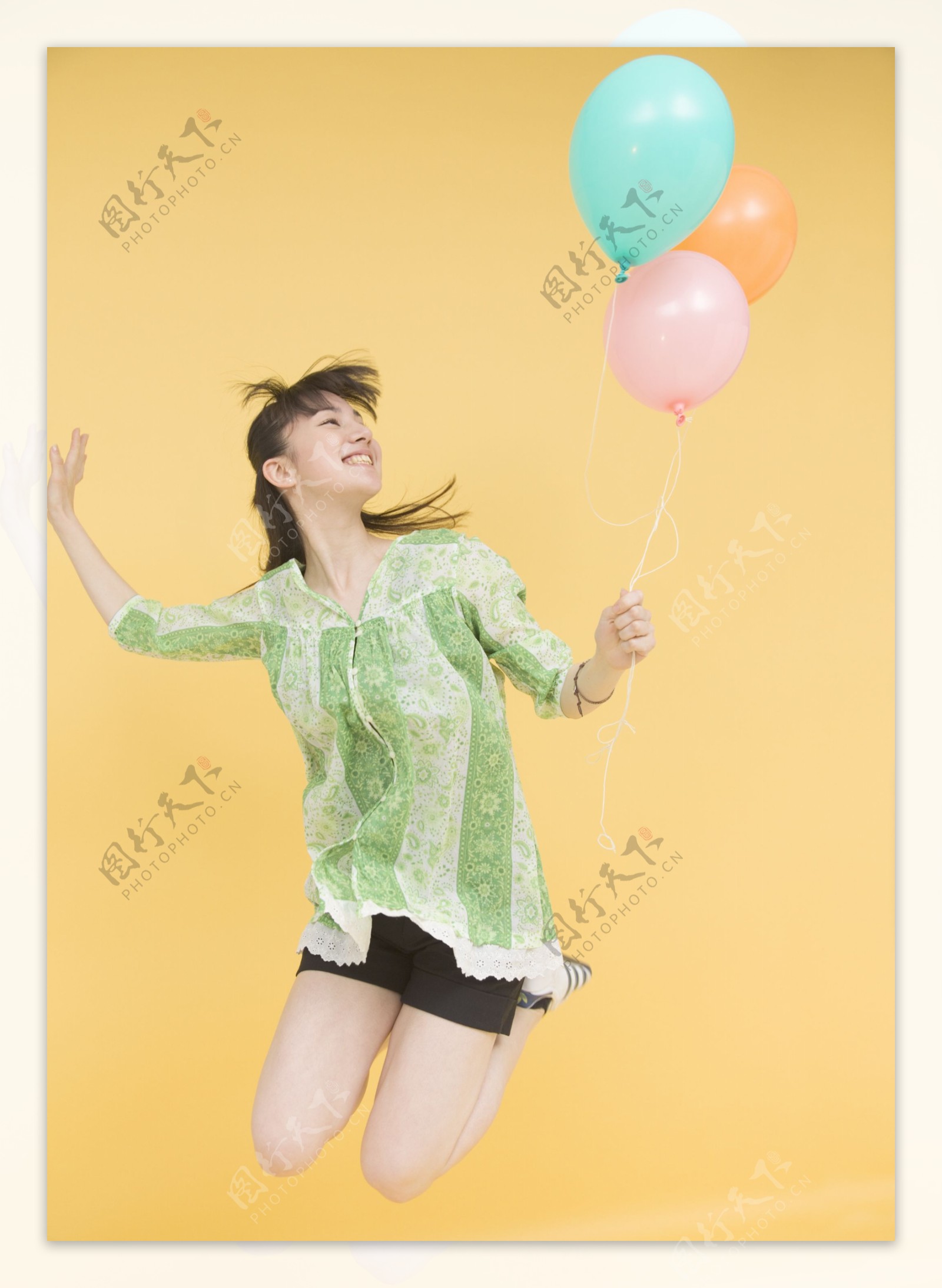 拿着彩色气球跳跃的美女图片
