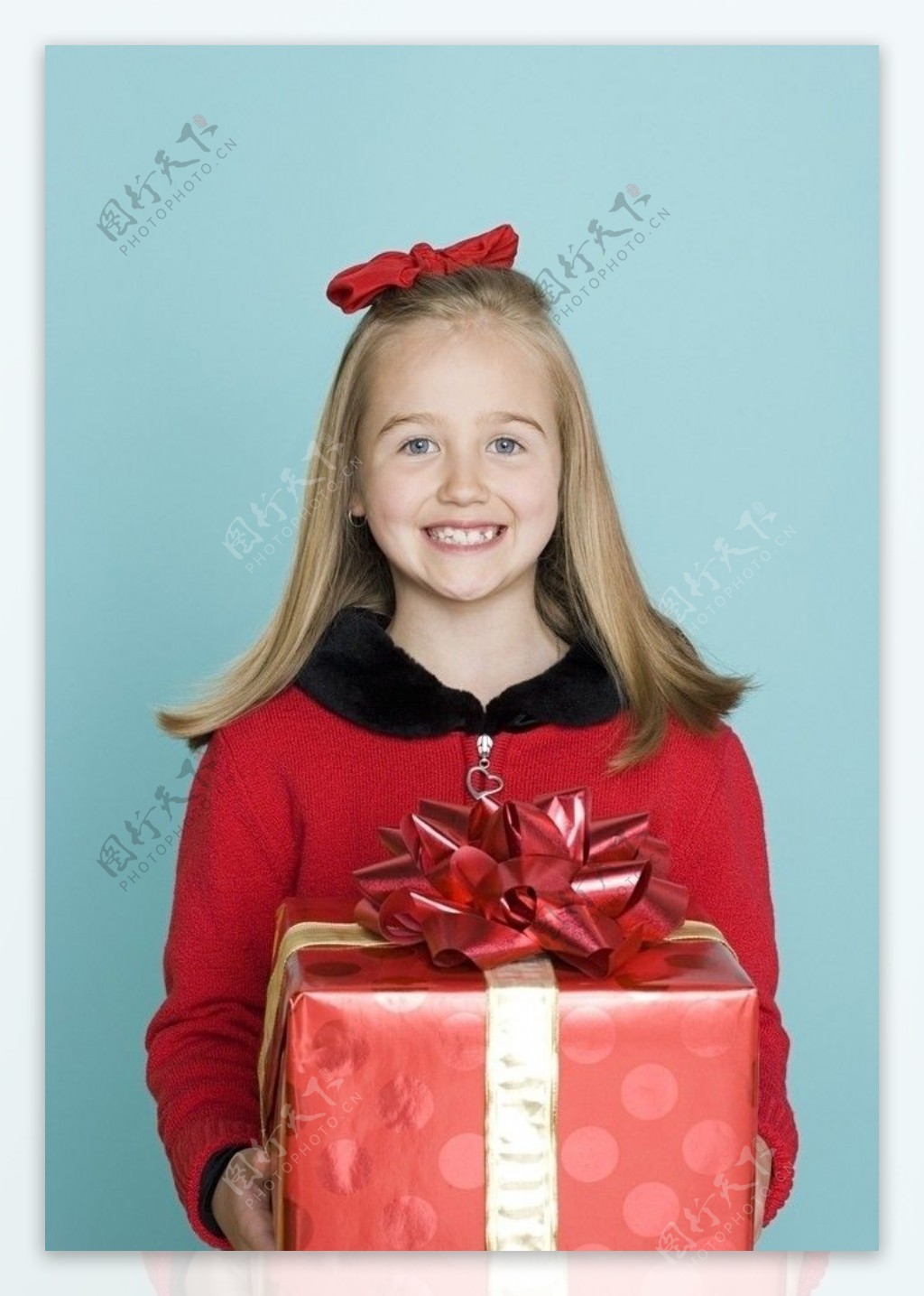 手捧礼盒的微笑小女孩图片