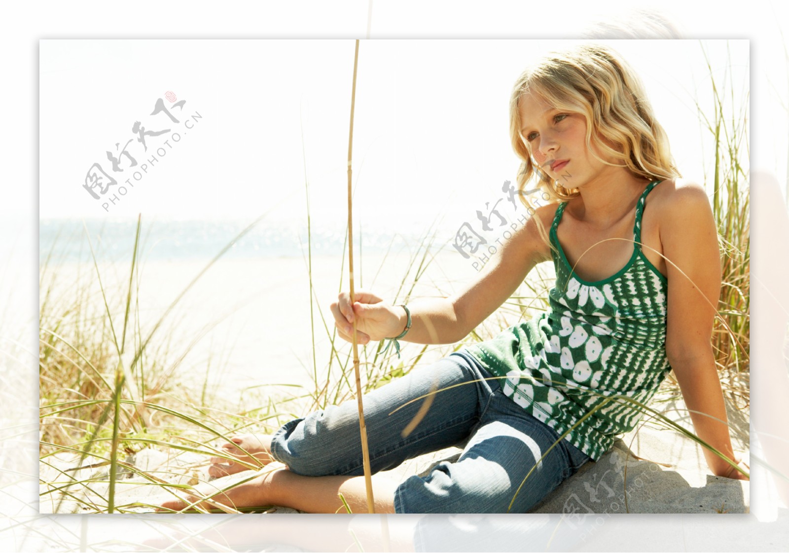 坐在沙滩上发呆的小女孩图片