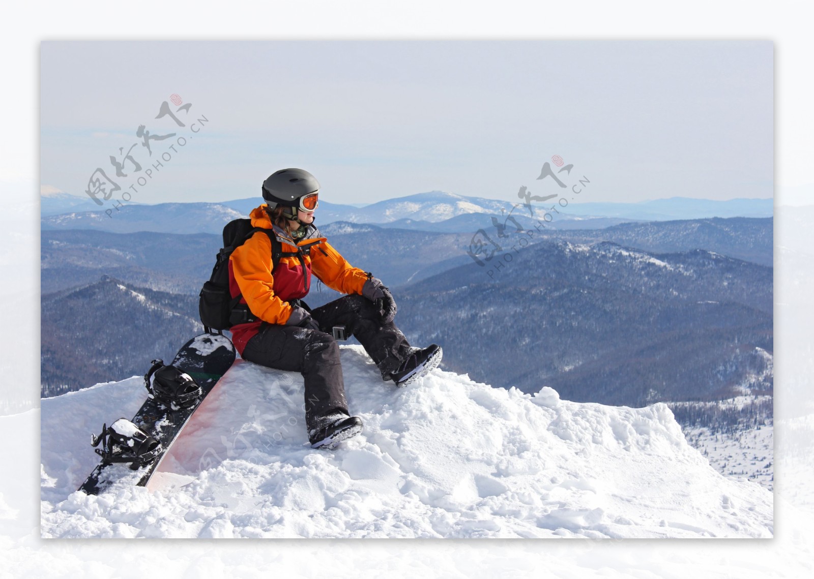 坐在雪山上的滑雪运动员图片