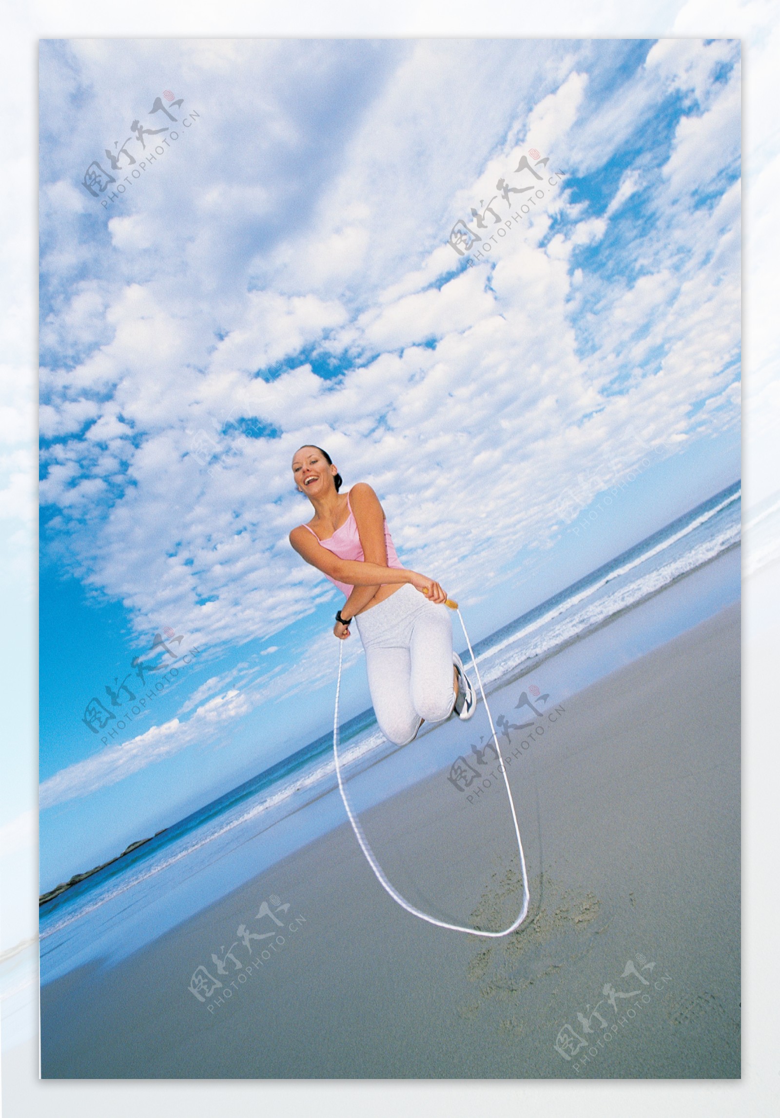 沙滩上跳绳的美女图片