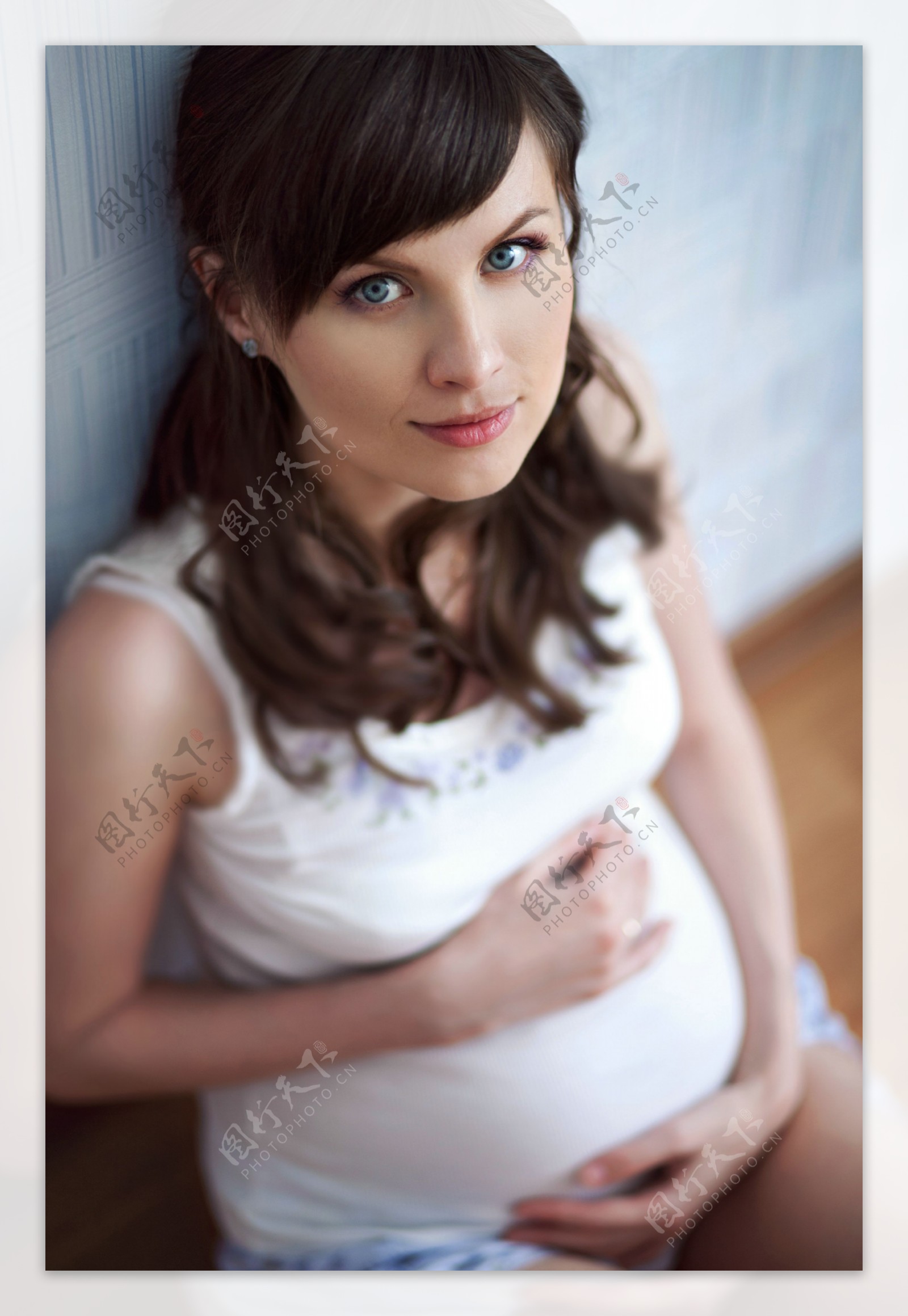 摸着肚皮向上看的孕妇图片
