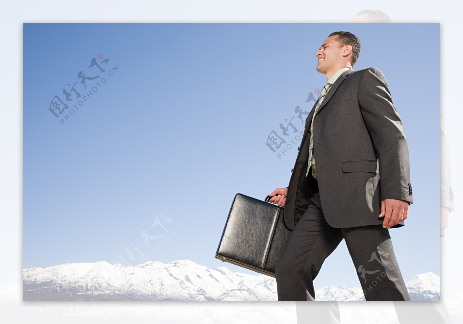 雪山边漫步的商务男士图片