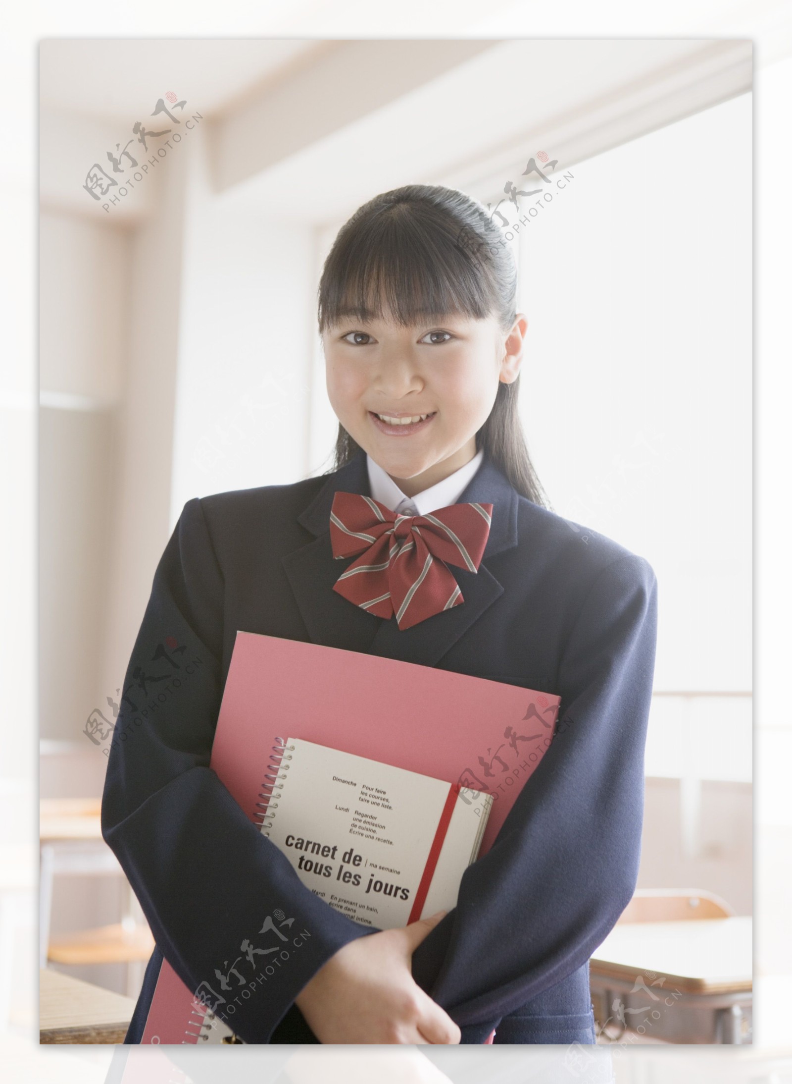 抱着书本的美女高中生图片