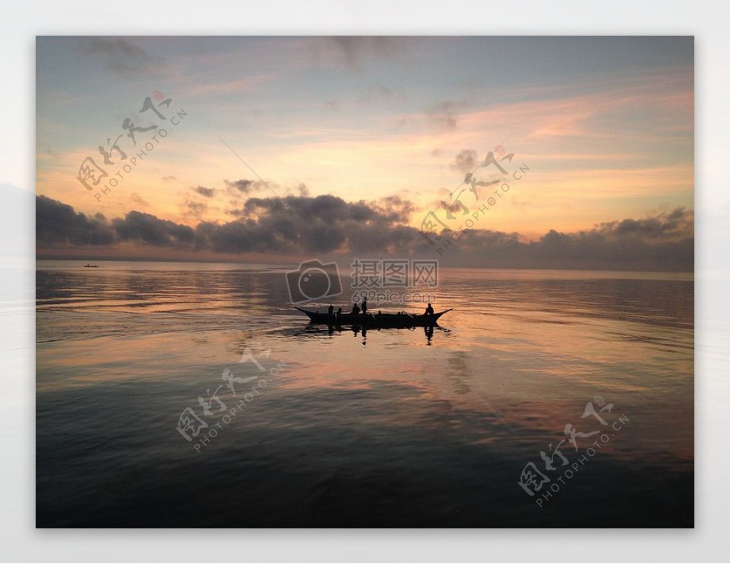剪影渔民在船在海上标签在蓝水和多云的天空日落