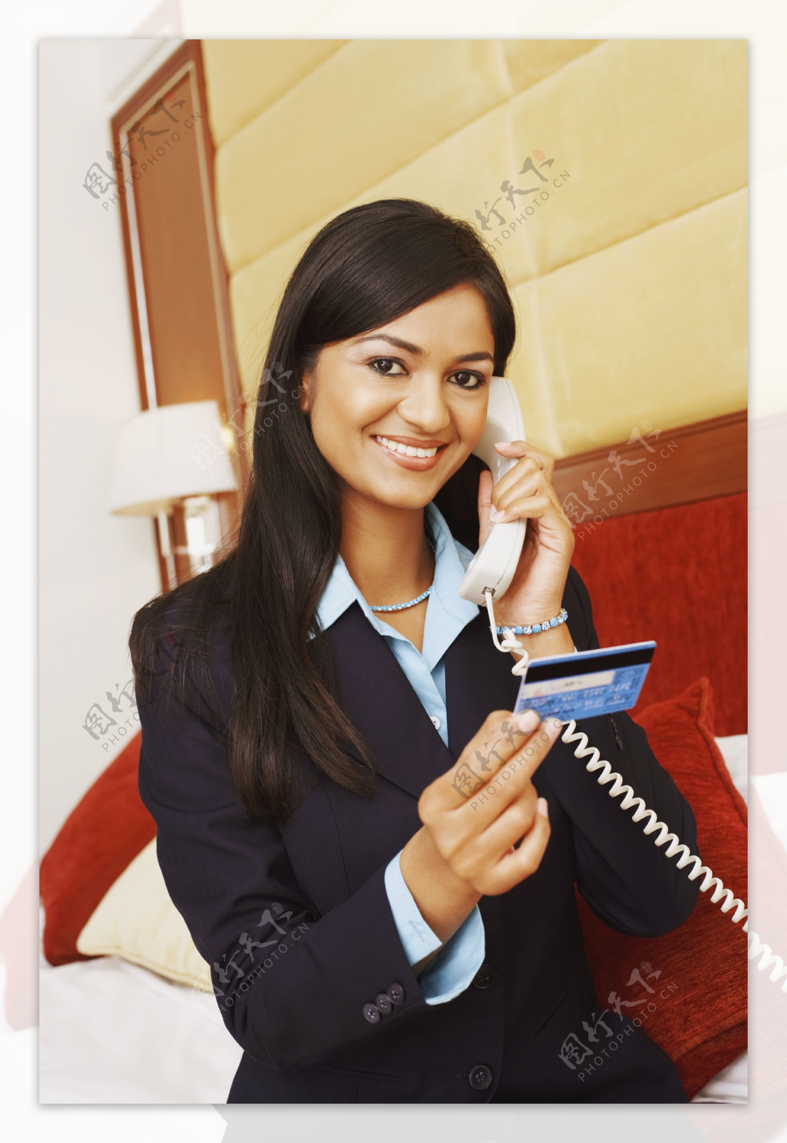 坐在床边手拿银行卡接电话的女人图片
