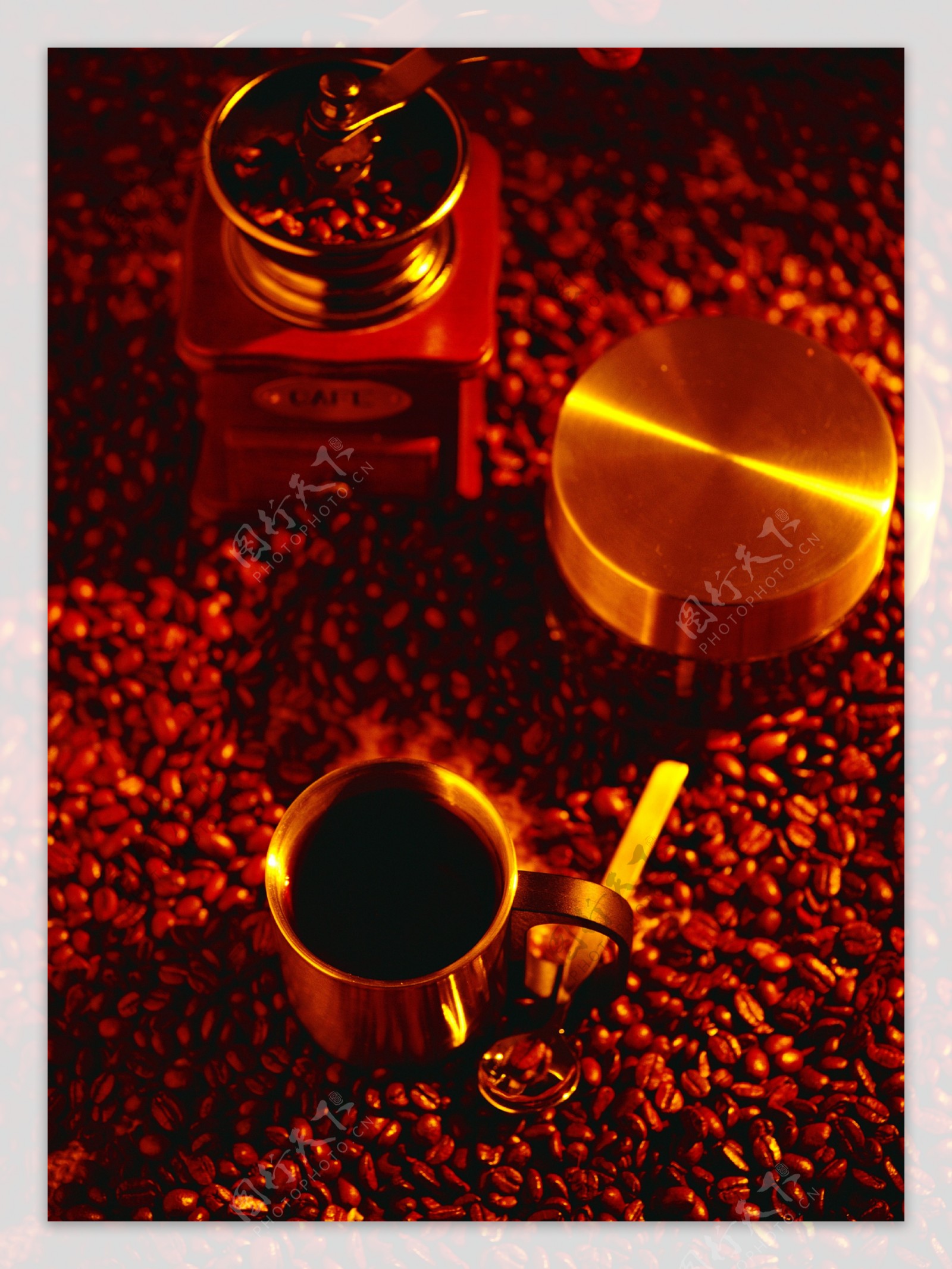 一堆褐色咖啡豆上的咖啡豆研磨机图片