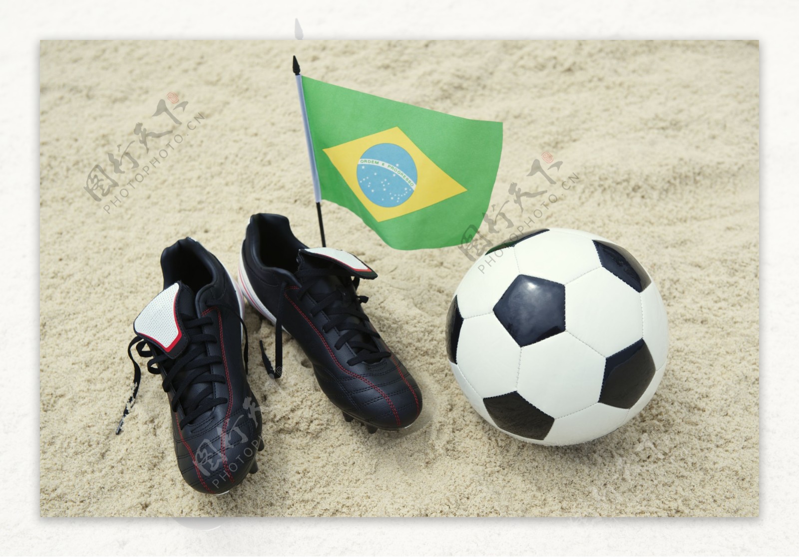沙滩上的球鞋与足球图片