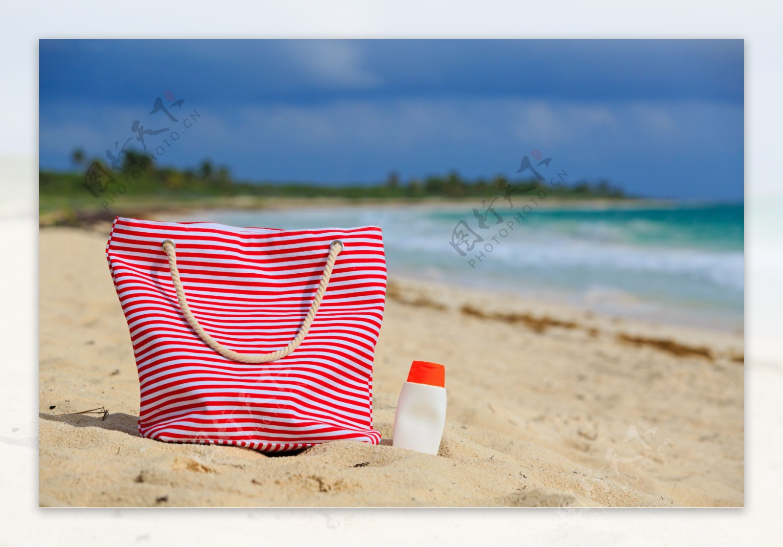 沙滩上的手提包防晒乳图片