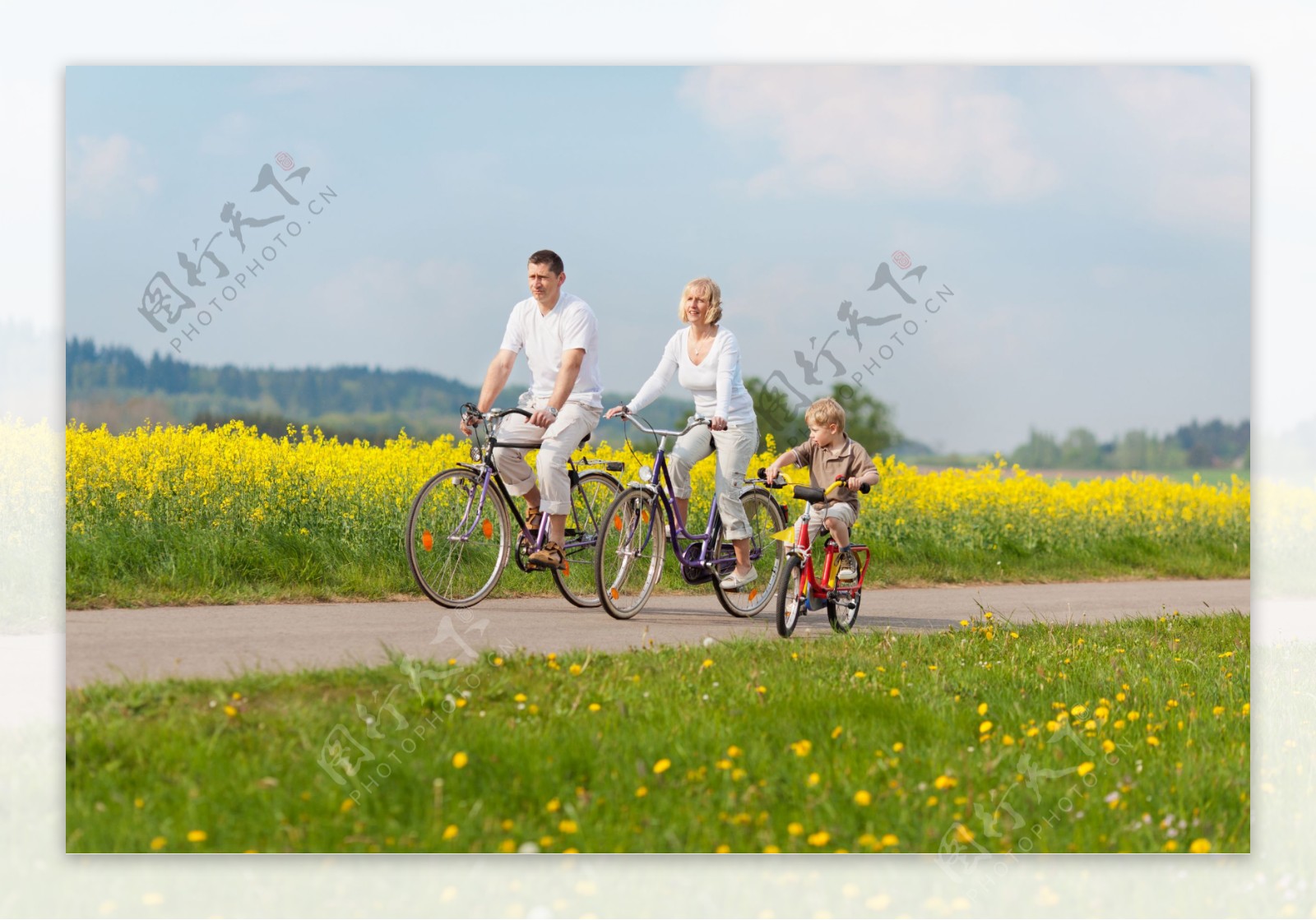 田野骑自行车的一家人图片