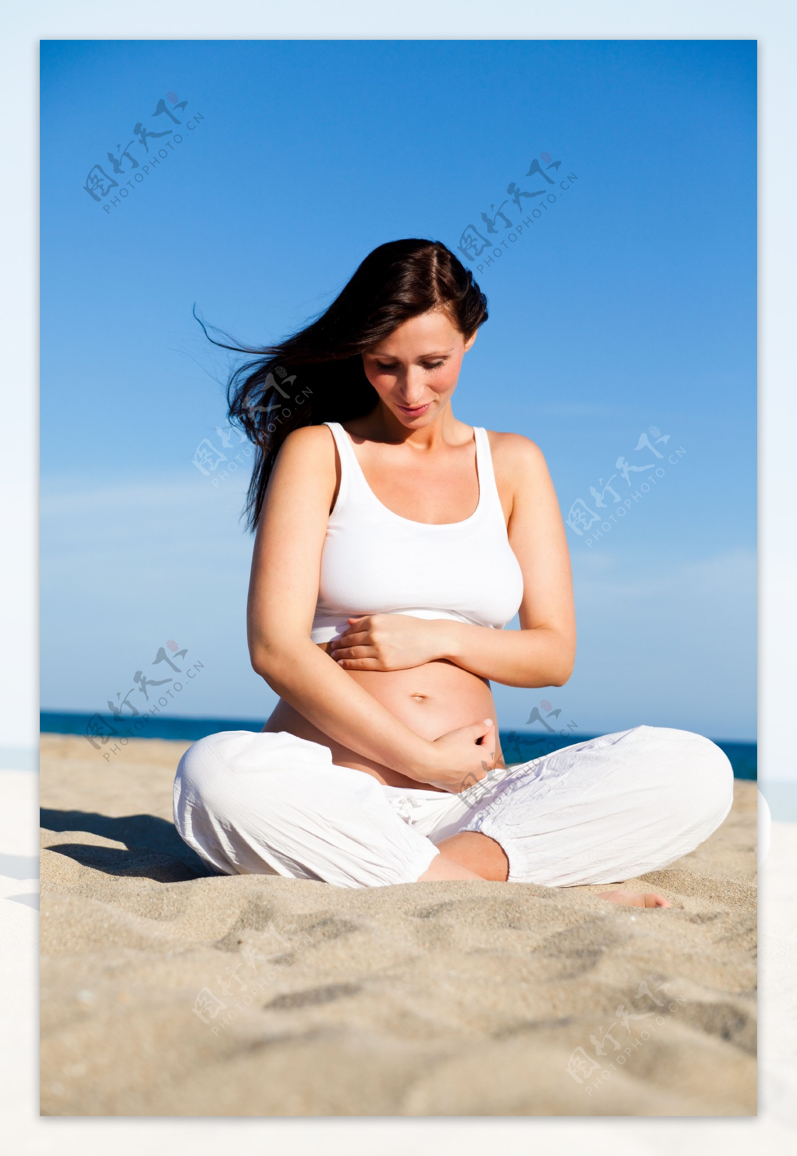 沙滩上坐着的孕妇图片