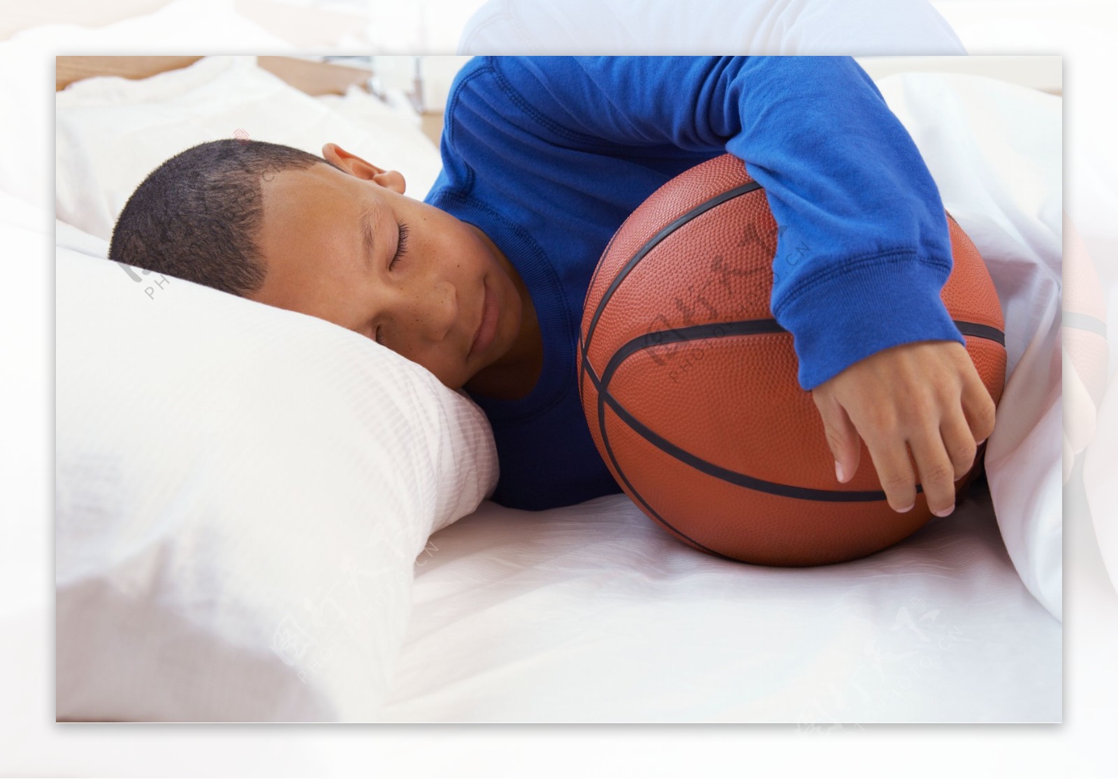 抱着篮球睡觉的儿童图片