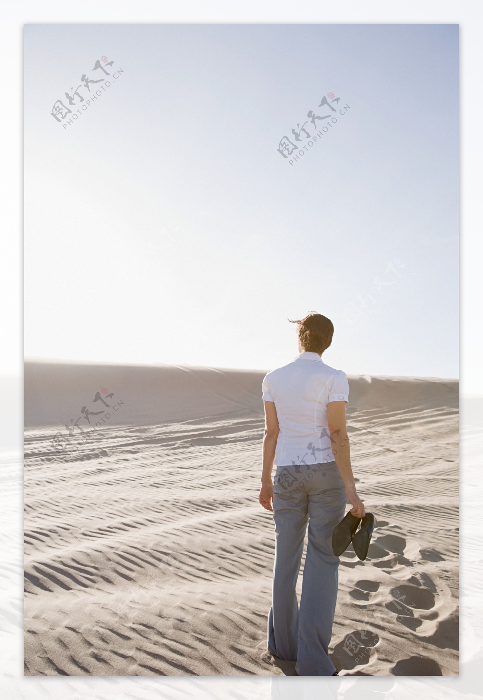 光脚走在沙漠中的女人背影图片