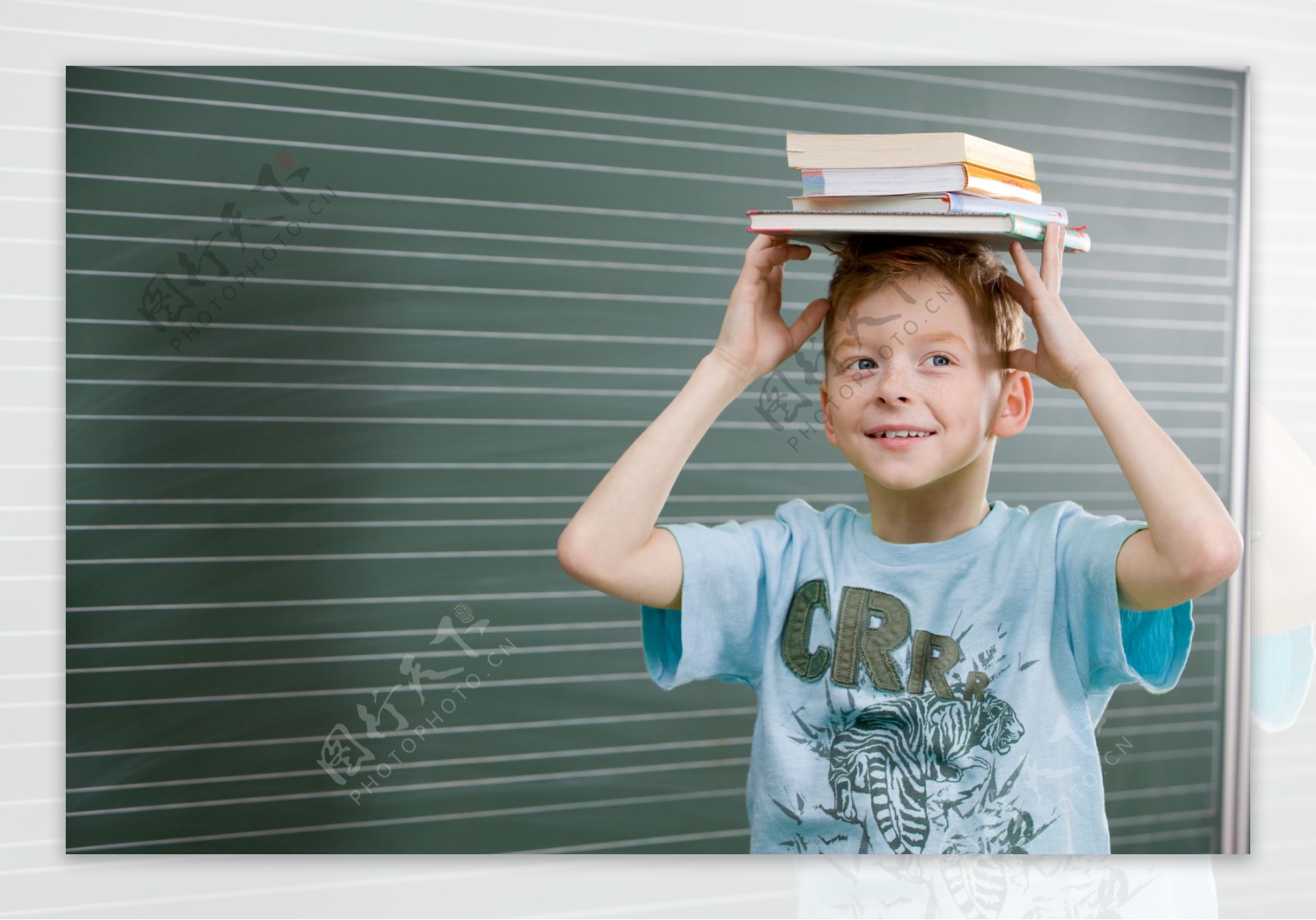 站着黑板前头顶着书本的小男孩图片