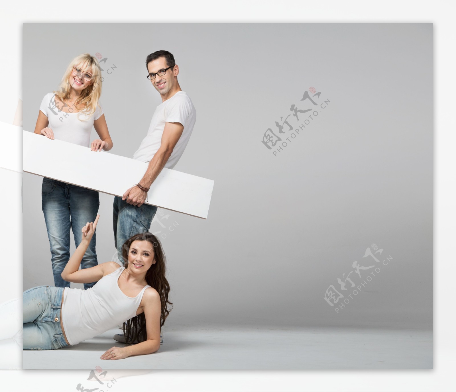 拿着长方形白板的男女和躺在地上的女人图片