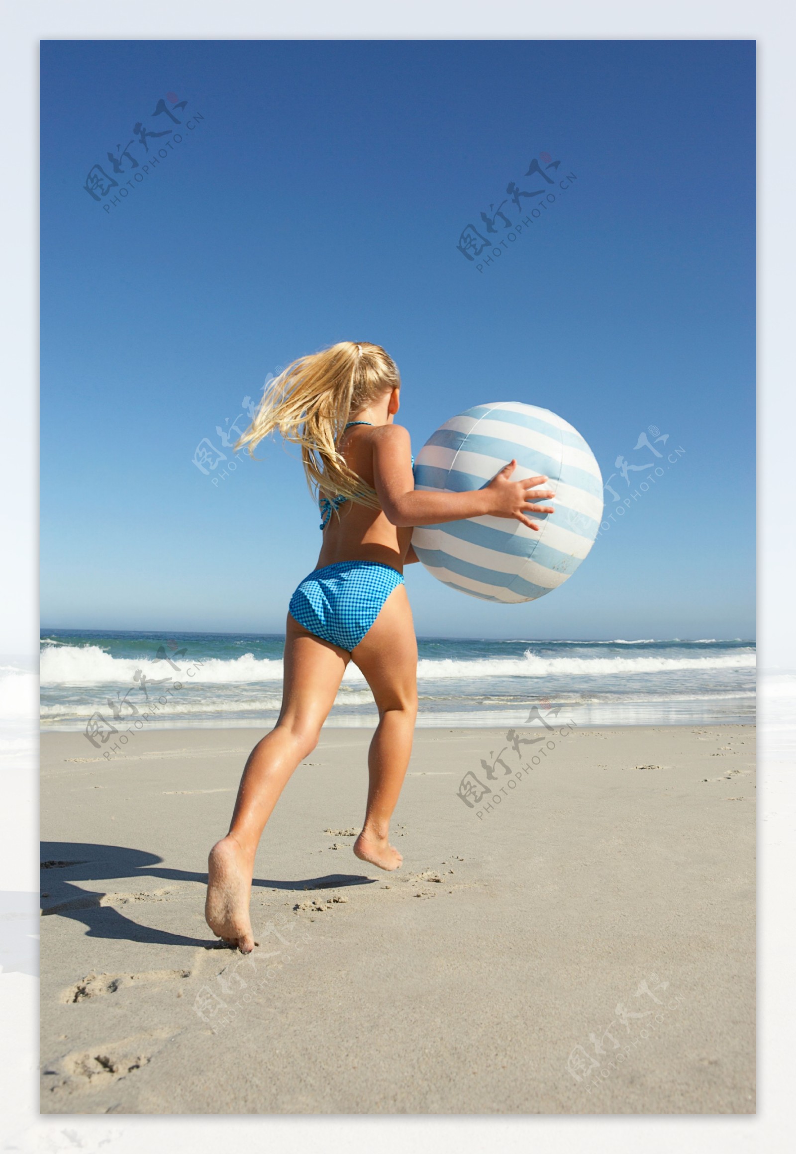 沙滩上玩皮球的美女图片