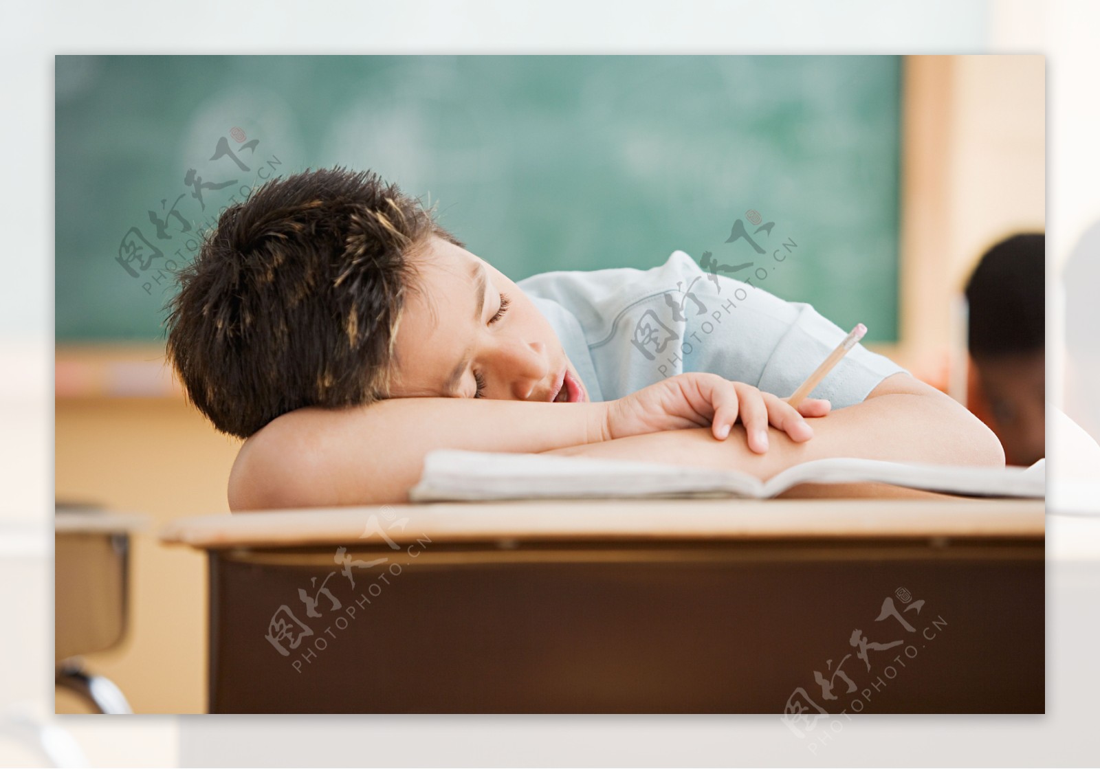 趴在课桌上睡觉的小男孩图片