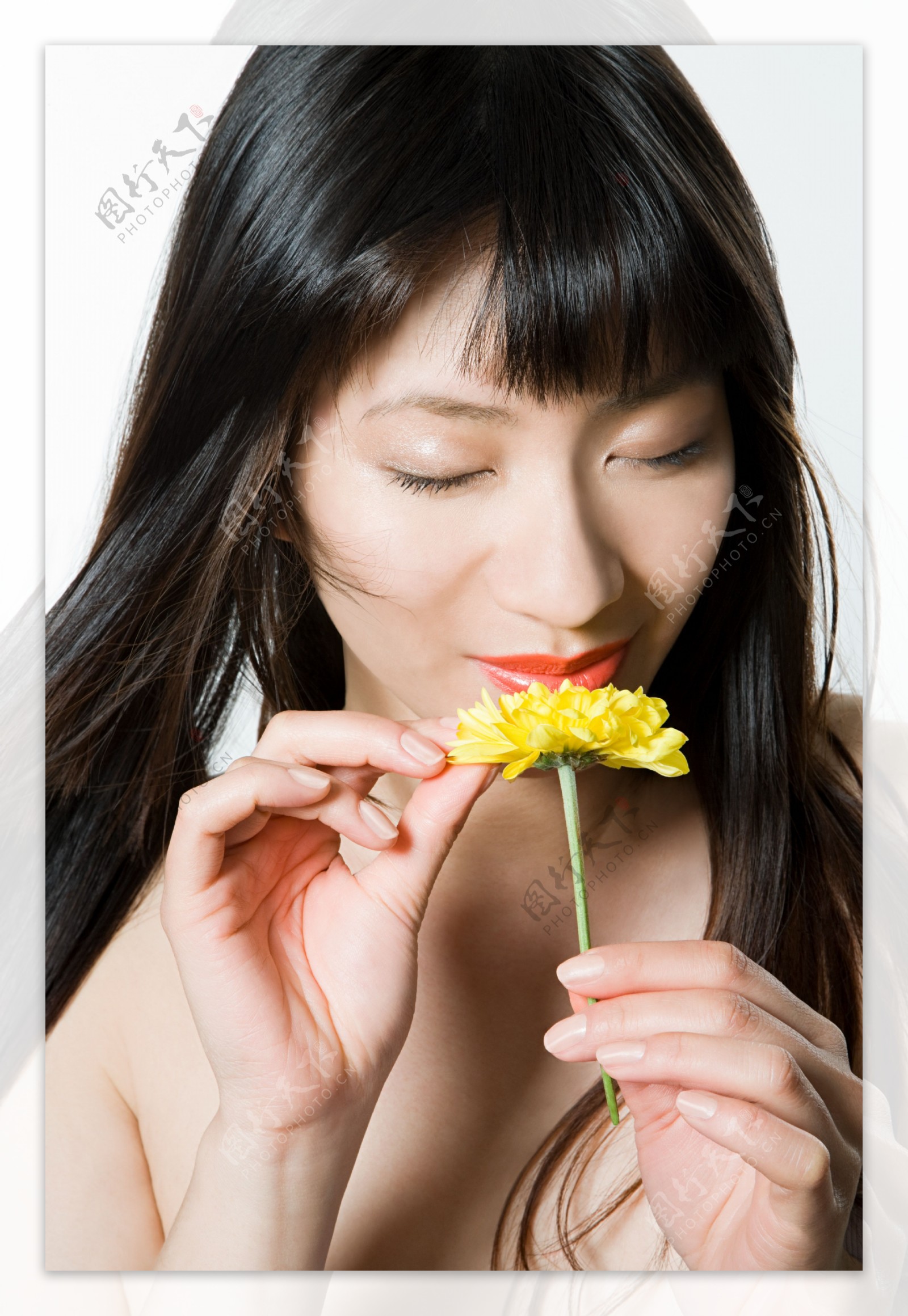 手拿花朵闻香的女人图片