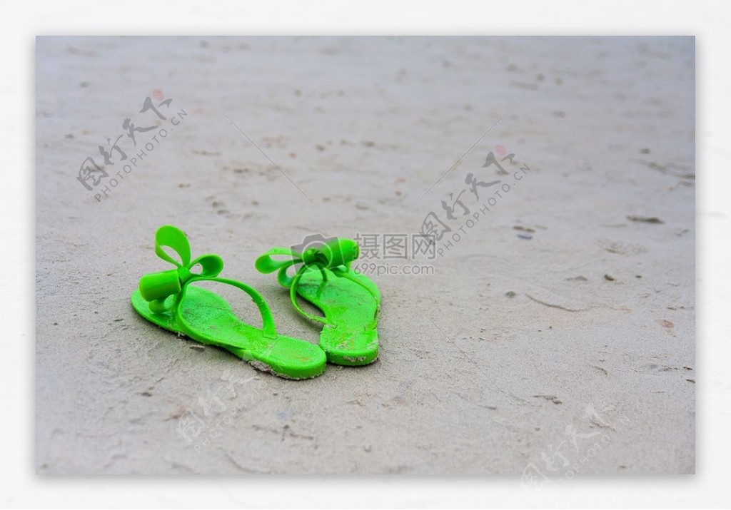 沙滩上的绿色拖鞋