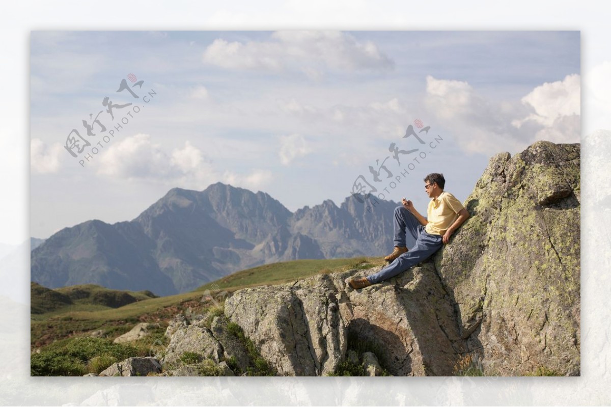 坐在岩石上休息的男人图片